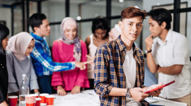 a group of young professionals standing around a table.